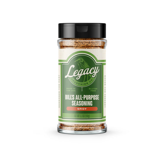 Shaker of Bill’s All-Purpose Seasoning: Spicy. The label features the company logo on a green background, with a light green drawing of a bird behind the logo.