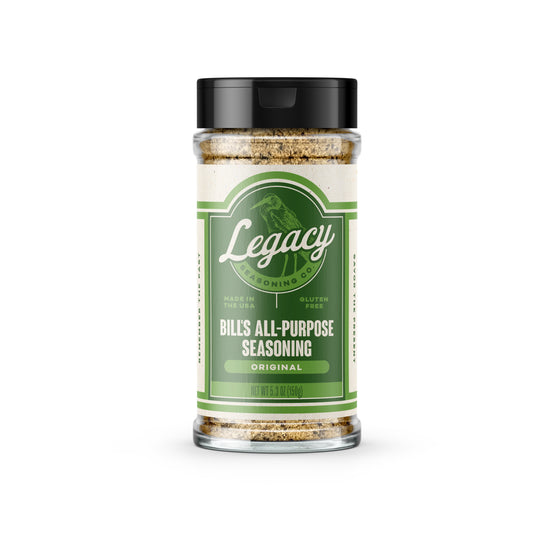 Shaker of Bill’s All-Purpose Seasoning. The label features the company logo on a green background, with a light green drawing of a bird behind the logo.