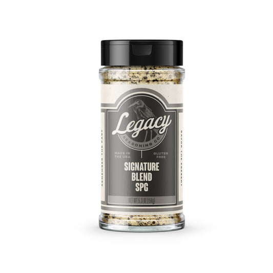 Shaker of Signature Blend SPG Seasoning. The label features the company logo on a dark grey background, with a light grey drawing of a bird behind the logo.